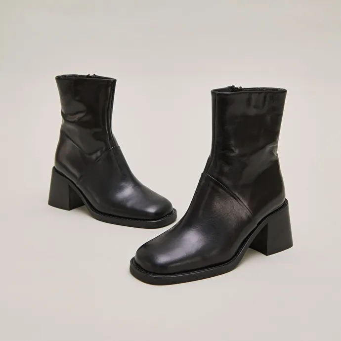 Square-toe boots with exposed seams in black leather