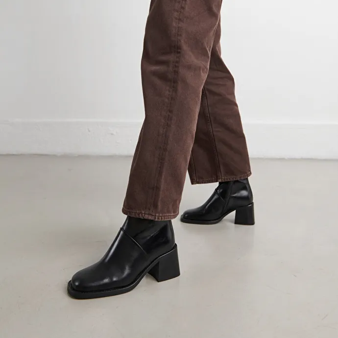 Square-toe boots with exposed seams in black leather