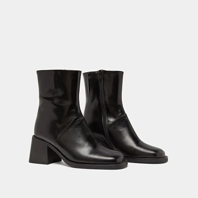 Square-toe boots with exposed seams in black leather