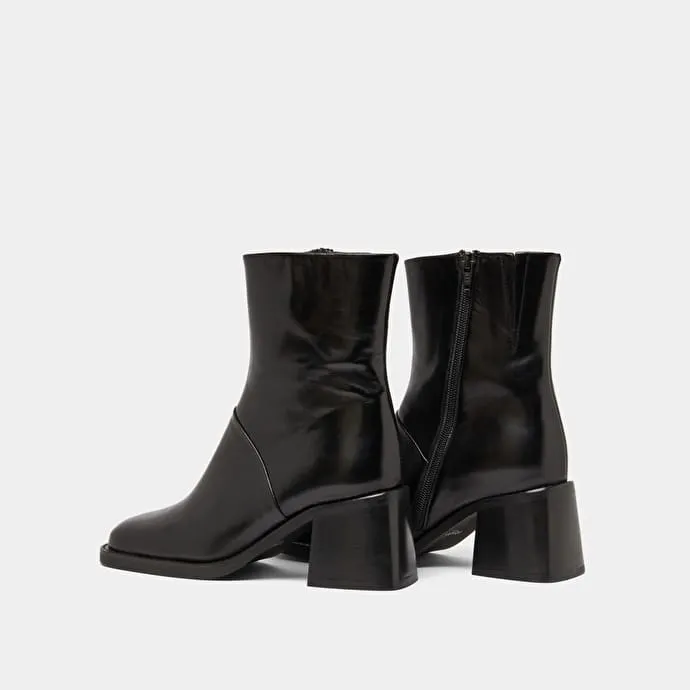 Square-toe boots with exposed seams in black leather